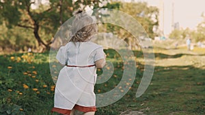 Funny Little Girl Running Away from Mom. Mother and Daughter in Dress Having Fun