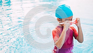 Funny little girl swims in a pool