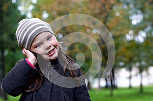 Funny little girl talking to a cell phone