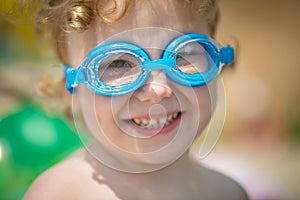 Funny little girl in water glasses