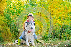 Funny little hugging cute dog pet. Dog friendly. Beautiful child girl playing with her dog. Autumn.