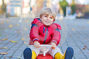 Funny little kid boy driving toy car outdoors