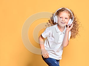 Funny little kid girl in white t-shirt isolated on yellow background. Childhood lifestyle concept. Mock up copy space