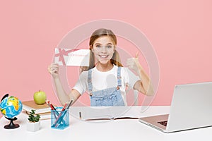 Funny little kid schoolgirl 12-13 years old study at desk with laptop isolated on pink background. School distance