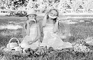 Funny little kids make sad and happy smiley emoticons with banana fruit at picnic on green grass on sunny summer