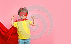 Funny little power super hero kid in red cloak and glasses. Superhero concept for kindergarten kids. Success, motivation