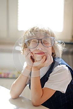 Funny little schoolboy in huge glasses has fallen into a reverie.