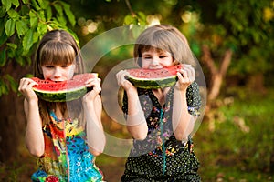 Funny little sisters girl eat watermelon in summer