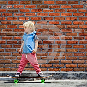 Funny little skater with skateboard before lesson