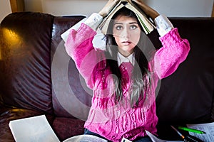 Funny looking brunette woman student trying to study in her room. Funny process of studying for exams photo