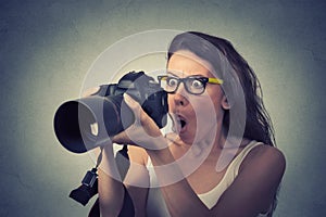 Funny looking young woman with digital camera