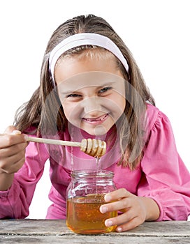 funny lovely little girl eat honey