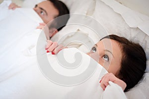 Funny lovers couple lying in the bed