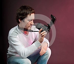 Funny male photographer looking into camera lens, man in studio