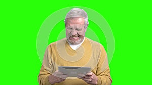 Funny male senior playing on pc tablet.