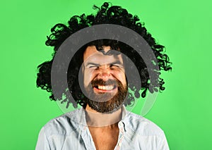 Funny man in black wig. Man with beard and mustache in curly periwig. Bearded hipster in black curly afro wig