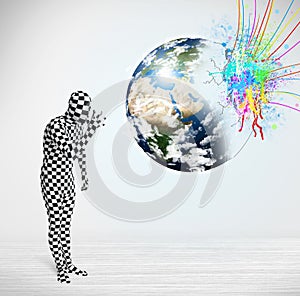 Funny man in body suit looking at colorful splatter earth