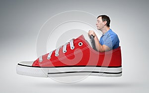 Funny man car driver with a wheel in red sneaker