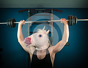 Funny man in comical mask doing sport exercise