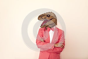 Funny man in dinosaur mask on studio background