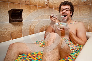 Funny man eating his cereals in the bath