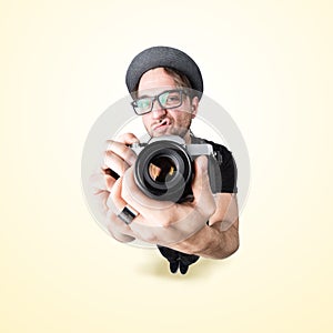 Funny man with a funny surprise expression shooting with his vintage reflex photo camera