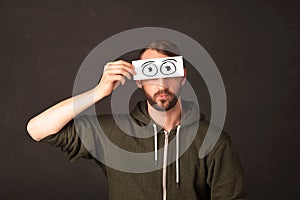 Funny man looking with hand drawn paper eyes