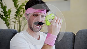 A funny man with a mustache clutches a hand trainer