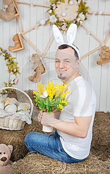 Funny man with rabbit ears holding flowers Easter holiday concept