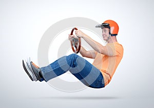 Funny man in red helmet car driver with wooden steering wheel, auto concept