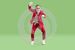 Funny man in red suit dancing gangnam style and having fun at New Year or Christmas party