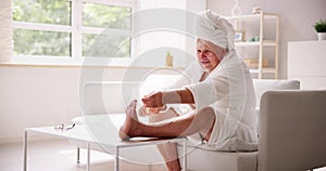 Funny Man Relaxing In Bathrobe Doing Spa Pedicure