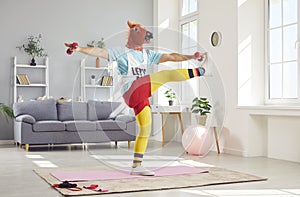 Funny Man In Retro Sportswear And Amusing Horse Mask Exercising At Home