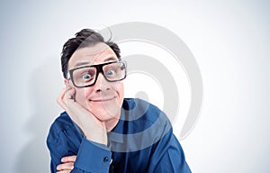 Funny man in a shirt and glasses props his head with his hand in an attentive listener pose. I am listening really carefully.