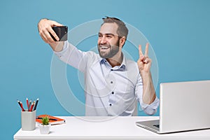 Funny man in shirt sit work at desk with pc laptop isolated on pastel blue background. Achievement business career