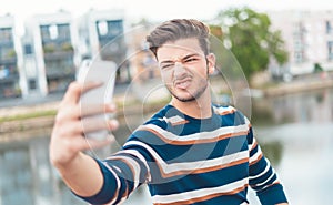 Funny man taking selfie with grimace expression