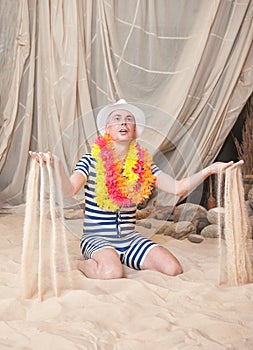 Funny man in vintage style striped swimsuit and colorful boa hold sand to sprinkle