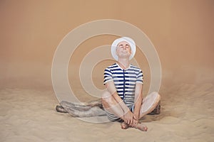 Funny man in vintage style striped swimsuit and white hat relaxi