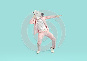 Funny man wearing bright pink suit in animal head horse mask dancing on studio blue background.