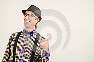 Funny man wearing retro clothes showing thumb up on white wall, copy space. Excited man in glasses shows like sign thumbs up and