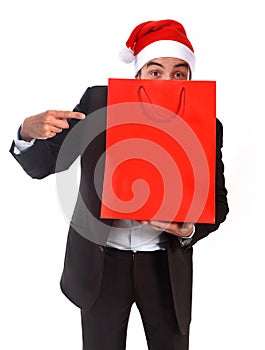 Funny man wearing Santa hat holding red shopping bag