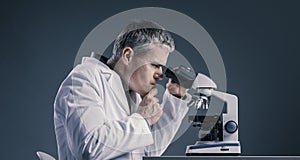 Funny medical scientist working with a microscope