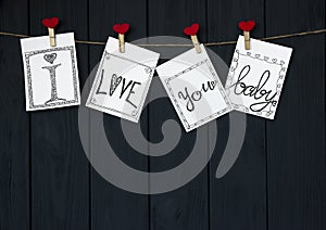 Funny Message on the four Valentine`s Cards says `I love you, baby!` natural Cord and Red pins hanging on rustic Driftwood text