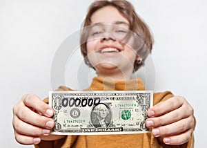 A funny millionaire girl holds a dollar with six zeros attached