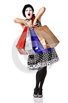 Funny mime in spotty dress holding shopping bags