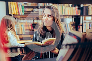 Funny Mom and Daughter Checking Some Books in a Library