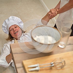 Funny mom and son relax in the kitchen after cooking. A tired woman and a boy are lying on the kitchen floor