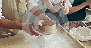 Funny momets kid's hands clapping in hands with flour while father sieving flour on wooden board.Cooking baking