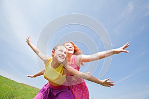 Funny mother and daughter on green grass