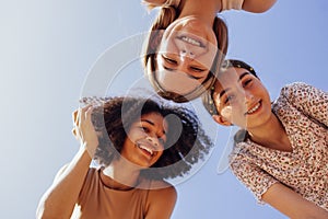 Funny multiracial smiling teenager gilrs standing and looking down at camera